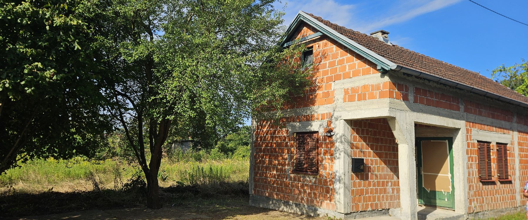 Außenansicht des Hauses mit unverputzter Ziegelfassade