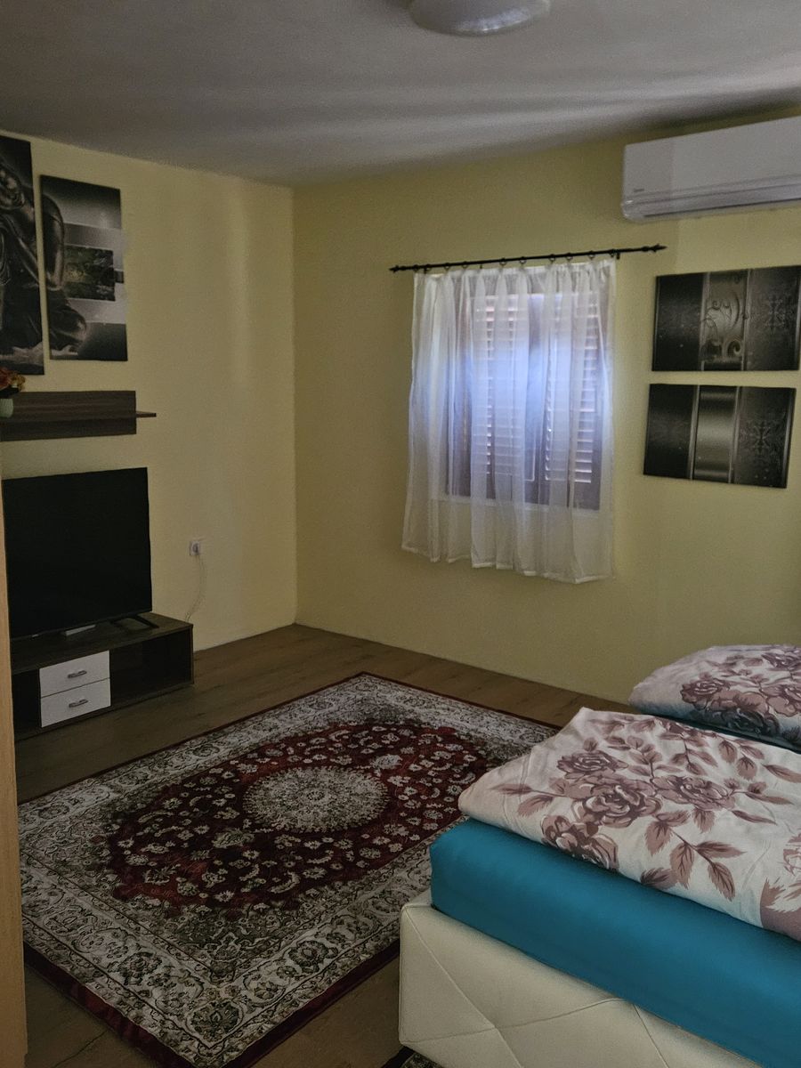 Schlafzimmer mit Doppelbett, Teppich und Klimagerät